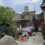 A house under construction featuring a cement wall and a ladder leaning against it.
