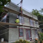 Construction workers actively building a house, showcasing teamwork and progress on a construction site.