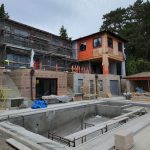 House under construction, showcasing scaffolding and building materials, indicating ongoing development and progress.
