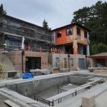 House under construction, showcasing scaffolding and building materials, indicating ongoing development and progress.