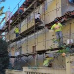Scaffolding set up alongside a building, providing support for construction or maintenance work.