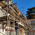 Scaffolding surrounds a building's exterior, providing support for construction or maintenance work.