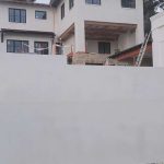 A construction site featuring a house under construction with white cement being applied to the structure.