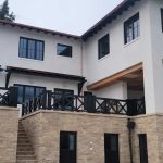 A two-story house featuring a balcony and exterior stairs leading to the upper level.